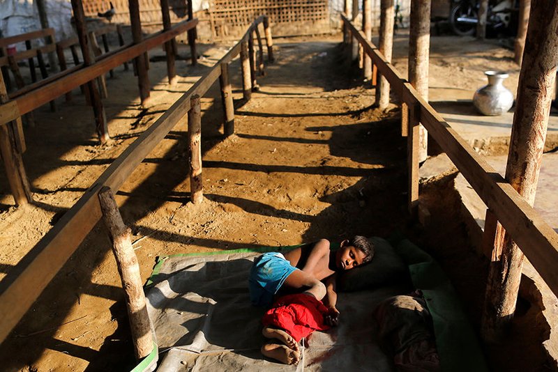 A Rohingya refugee boy sleeps inside a camp March 15 in Sittwe