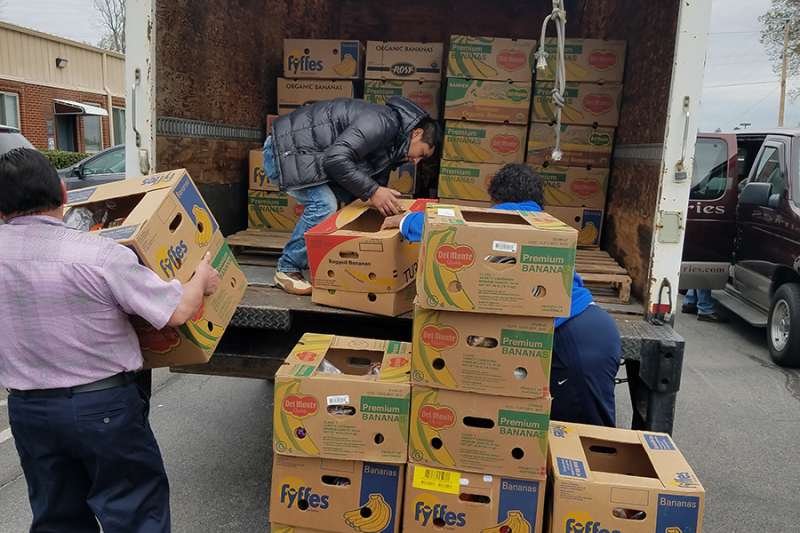 Volunteers unload boxes of donations for immigrant families at St. Patrick Catholic Church in Morristown