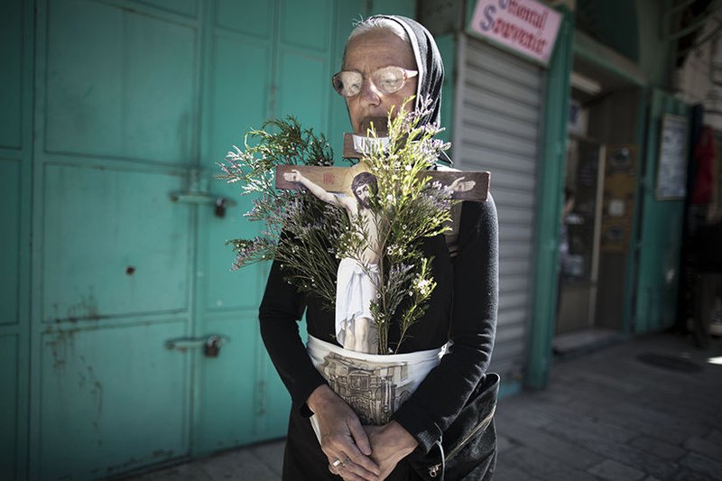 A Christian worshipper holds a cross outside the Church of the Holy Sepulcher in Jerusalem in this 2014 file photo. (CNS photo/Abir Sultan
