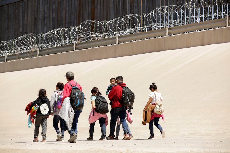Migrants walk after crossing the Bravo River at the border line between Ciudad Juarez