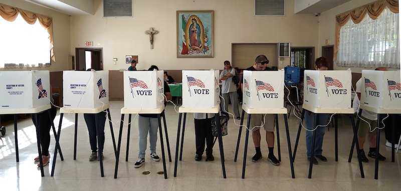 Voters mark their ballots under an image of Our Lady of Guadalupe at Assumption Catholic Church in Los Angeles during the midterm elections Nov. 6, 2018. (CNS photo/Mike Nelson)
