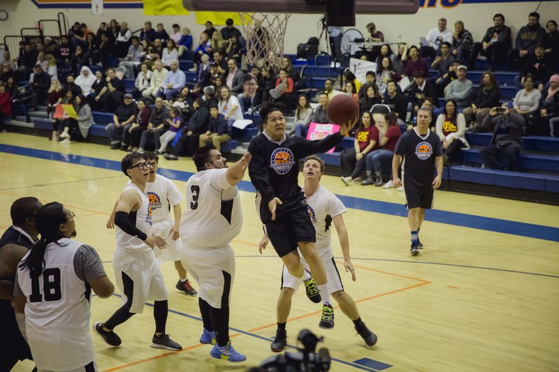 Fr. Andrew Chung of Team Priests driving to the basket around Team Seminarian player Daniel Gonzalez. (DIMA OTVERTCHENKO/ANGELUS)