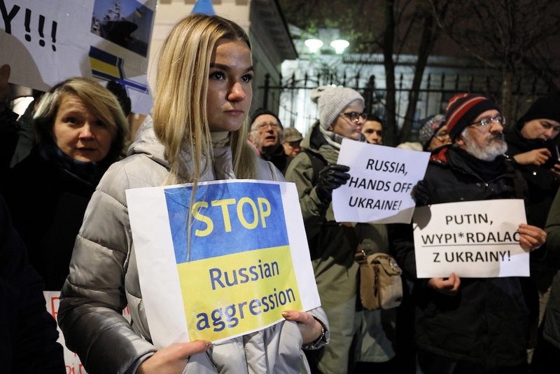 People gather to protest in front of the embassy of the Russian Federation Nov. 26 in Warsaw