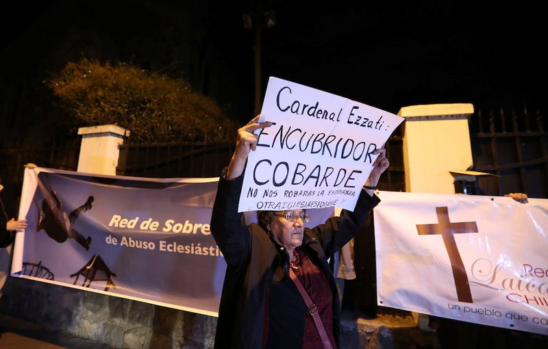 A demonstrator displays a banner during a rally against Chilean Cardinal Ricardo Ezzati over allegations he covered up sexual abuse of minors outside his residence in Santiago. The banner reads: "Cardinal Ezzati: Coward covering up! They will not steal our hope. Another church is possible" and "Survivors Network of Ecclesiastical Abuse." (CNS photo/Ivan Alvarado