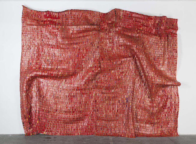 “Red Block” by Ghana-born artist El Anatsui is made of flattened foil labels from the necks of liquor bottles.