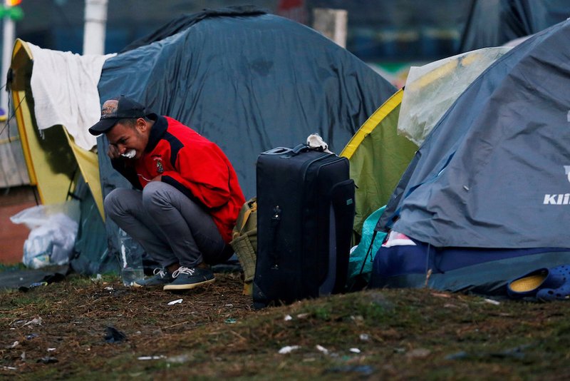 A Venezuelan migrant brushes his teeth outside his tent at a makeshift camp Nov. 26 in Bogota