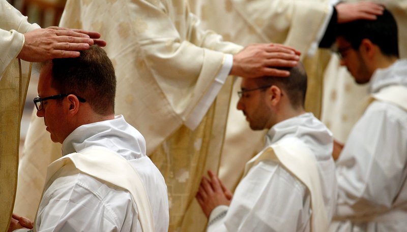 Priests put their hands on the heads of newly ordained priests during an ordination Mass celebrated by Pope Francis in St. Peter's Basilica at the Vatican May 12, 2019. (CNS photo/Yara Nardi, Reuters)
