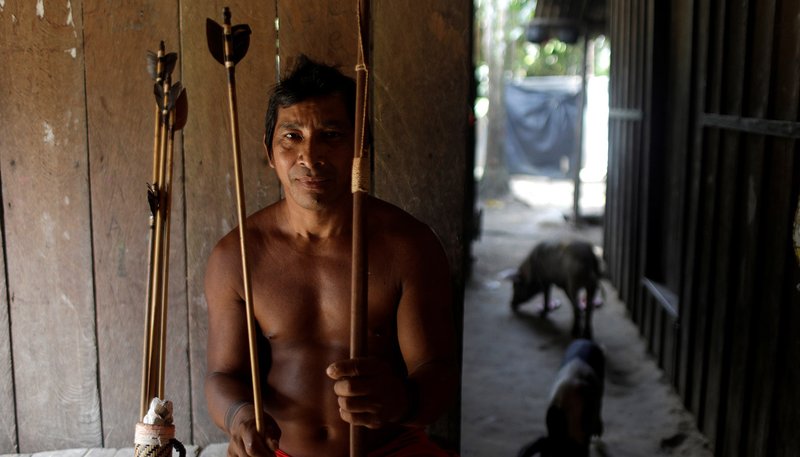 A member of the Tembe indigenous tribe, which is facing a conflict with illegal loggers on its land, holds his bow and arrows in Teko-haw indigenous village near Paragominas, Brazil, Sept. 9, 2019. A report released Sept. 24 from the Brazilian bishops' Indigenous Missionary Council shows the number of indigenous murdered last year increased by more than 20% in comparison to 2017. (CNS photo/Ricardo Moraes, Reuters)