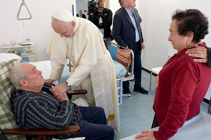 Pope Francis visits with a patient Oct. 4 at St. Raphael Borbona Assisted Living Facility in Rieti