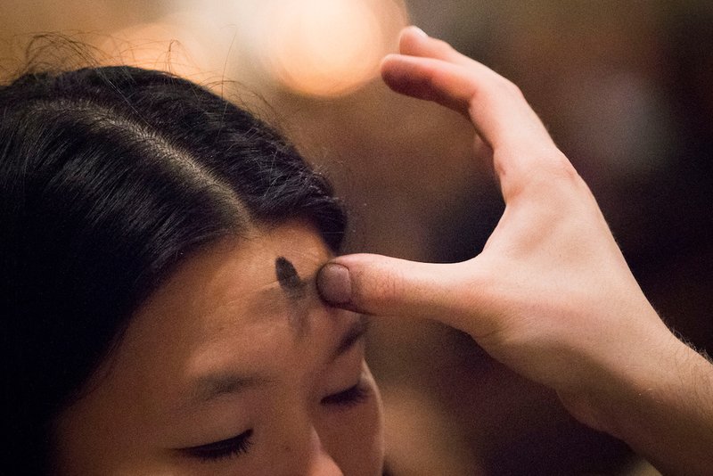 A cross is marked on the forehead of a woman during Ash Wednesday Mass at St. Patrick's Cathedral in New York City Feb. 14