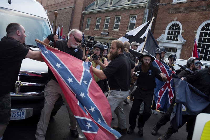 People struggle with a Confederate flag as a crowd of white nationalists are met by a group of counter-protesters in early August in Charlottesville