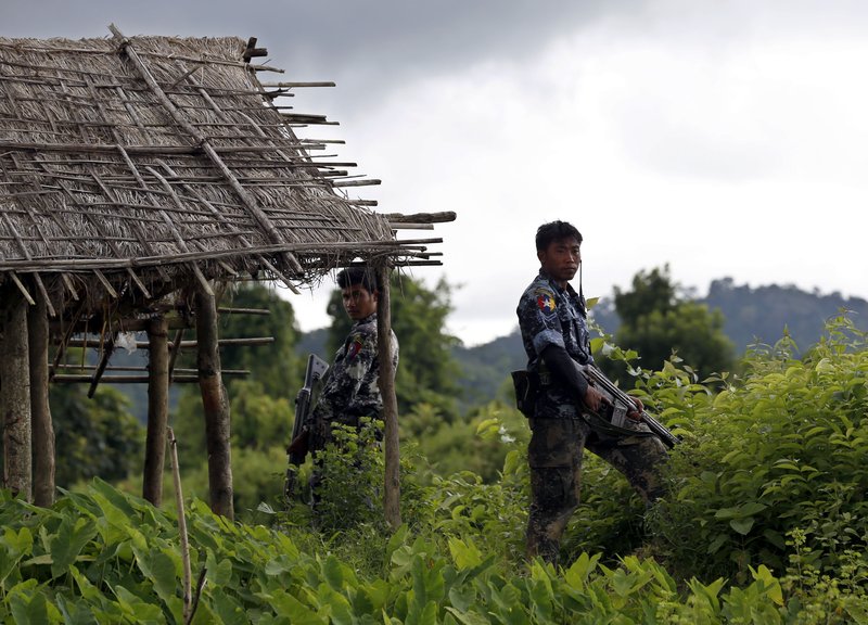 Police stand guard in 2017 after finding 10 bodies buried in a mass grave in the village of Maungdaw