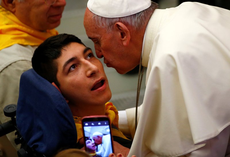 Pope Francis kisses a disabled young man during a special audience with members of Doctors with Africa at the Vatican May 7. (CNS photo/Tony Gentile