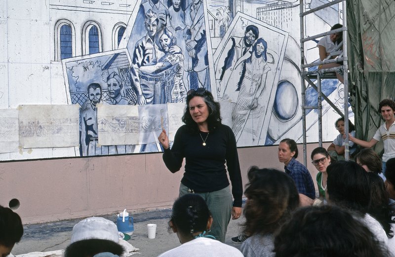 Judith F. Baca and the mural makers meet in front of the 1940s section of The Great Wall of LosAngeles