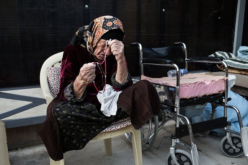 A displaced Iraqi woman prays the rosary in 2014 inside St. Joseph Church in Irbil