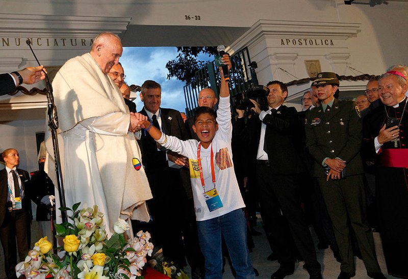 A boy cheers as he greets Pope Francis outside the Apostolic Nunciature in Bogota