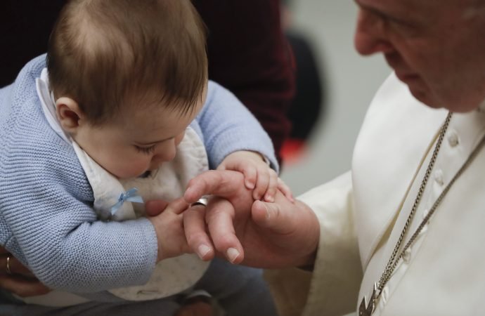 A baby touches Pope Francis's ring during the weekly general audience
