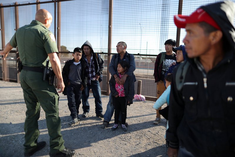 A group of Central American migrants is questioned about their children's health after surrendering to U.S. Border Patrol agents south of the U.S.-Mexico border fence in El Paso