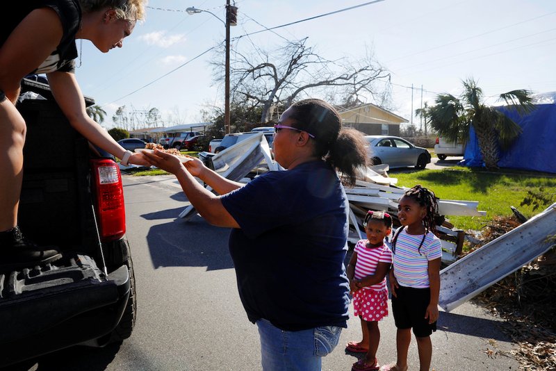 A member of 50 Star Search and Rescue distributes hot food prepared by Operation BBQ Relief Oct. 16 in the aftermath of Hurricane Michael in Springfield