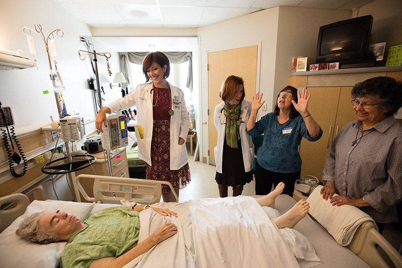 Nurse Rebekah Riemer and nurse manager Marianne Ayala gather around patient Linda Ficher with relatives. (photo/Victor Aleman)