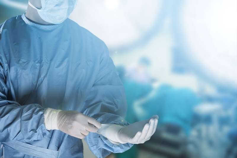 Medical team preparing equipment for surgery in operation room. Via Shutterstock
