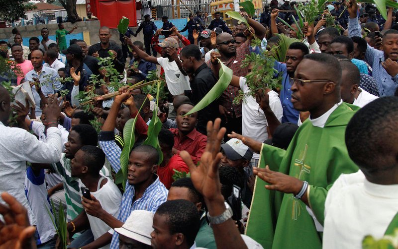 A priest and other demonstrators chant slogans during a protest organized by Catholic activists in Kinshasa