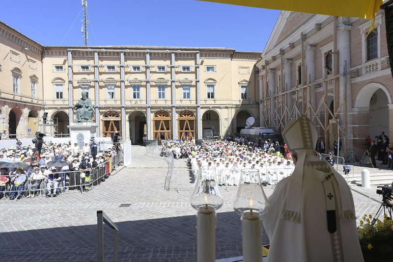 Pope Francis and Archbishop Francesco Massara of Camerino-San Severino Marche pray before a partially destroyed statue of Mary in the cathedral of Camerino