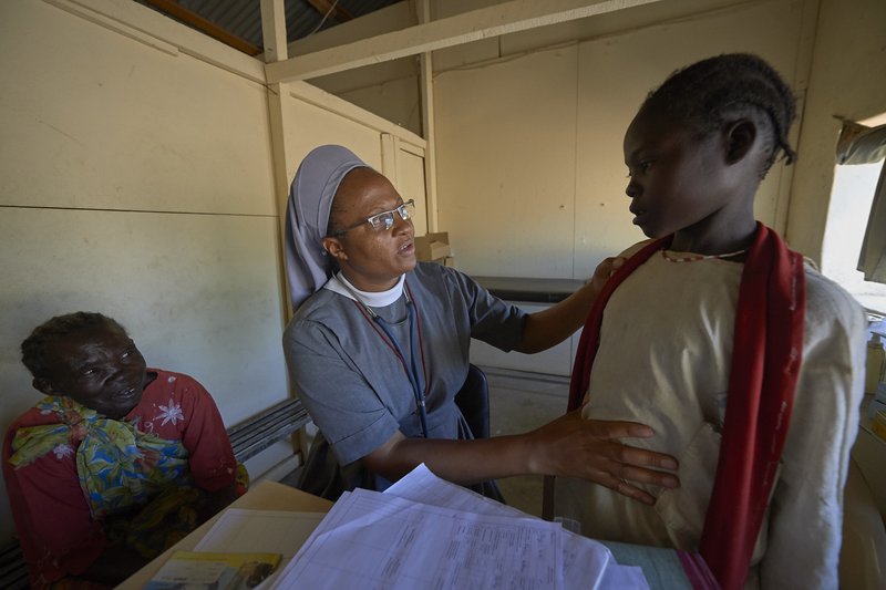 Precious Blood Sister Catherine Tukay examines a young patient in the Catholic clinic in Kauda