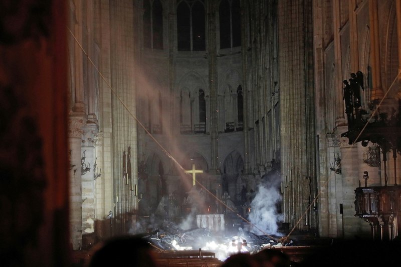 Smoke rises around the altar inside Notre Dame Cathedral in Paris as a fire continues to smolder early April 16