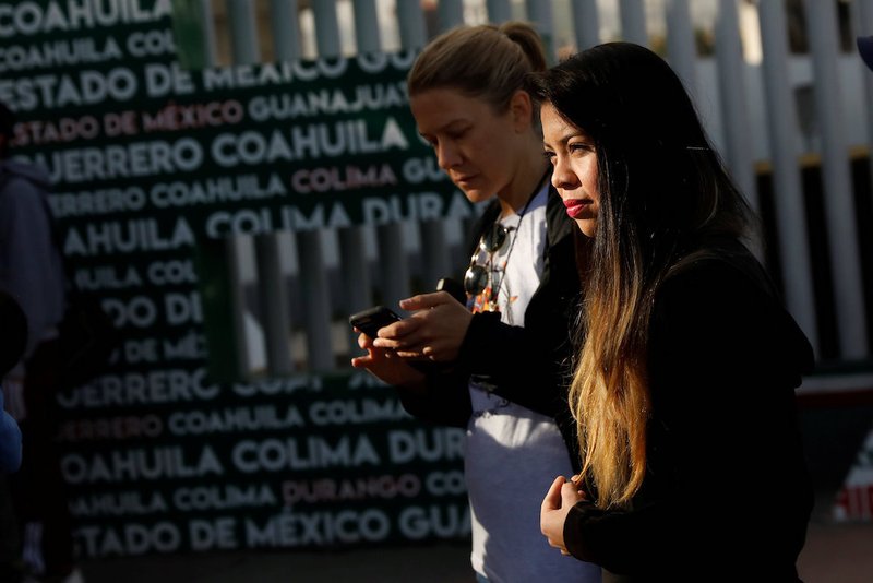 A woman waits for her number to seek asylum in the United States at the Chaparral border crossing in Tijuana