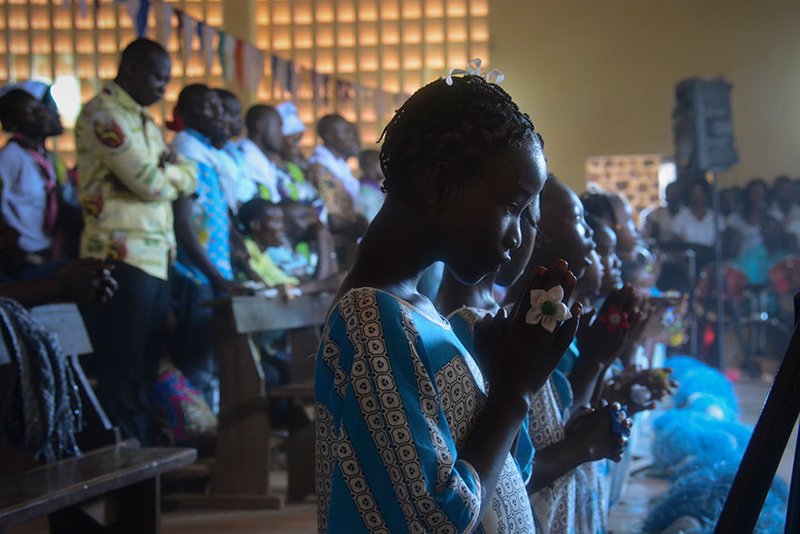 Young women pray during Mass Nov. 22