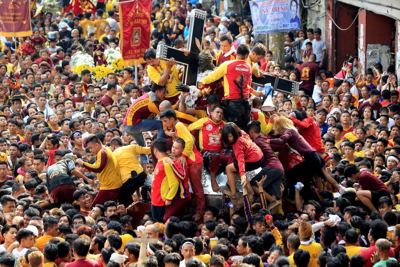 Pilgrims climb to touch the Black Nazarene during Jan. 7 procession in Manila