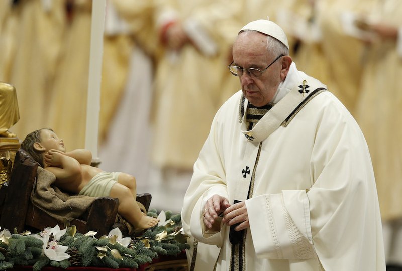 Pope Francis finishes venerating a figurine of the baby Jesus during Mass marking the feast of the Epiphany in St. Peter's Basilica at the Vatican Jan. 6. (CNS photo/Paul Haring)