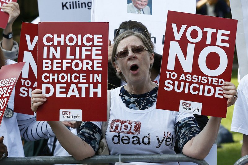 A demonstrator against assisted suicide joins a protest outside Parliament in London Sept. 11