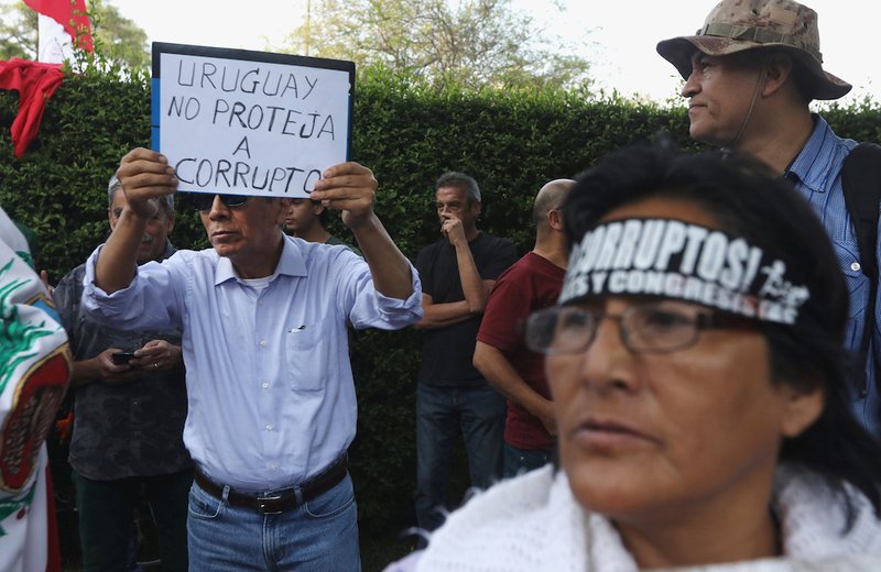 A man opposed to former Peruvian President Alan Garcia holds a sign Nov. 18 reading "Uruguay