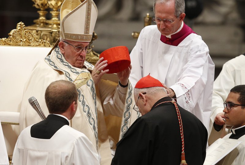 Pope Francis places a red hat on new Cardinal Louis Raphael I Sako