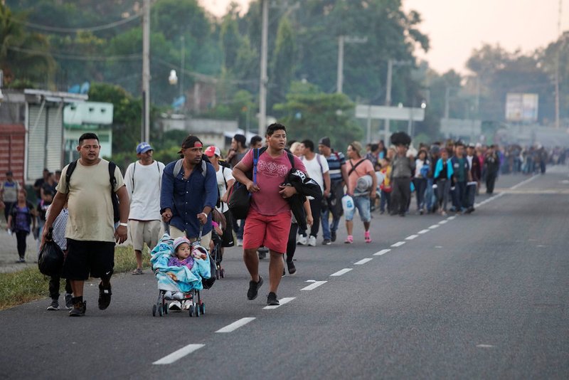 Part of a caravan of Central American migrants walk along a road in Ciudad Hidalgo