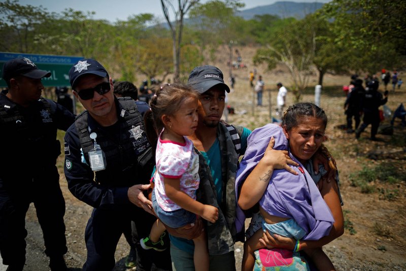 A family of Central American migrants is detained by Mexican federal police officers April 22