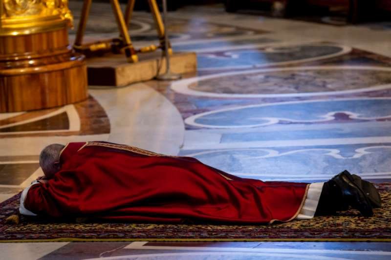 Pope Francis prostrates himself before the altar of St. Peter's Basilica at the opening of the Good Friday liturgy April 19