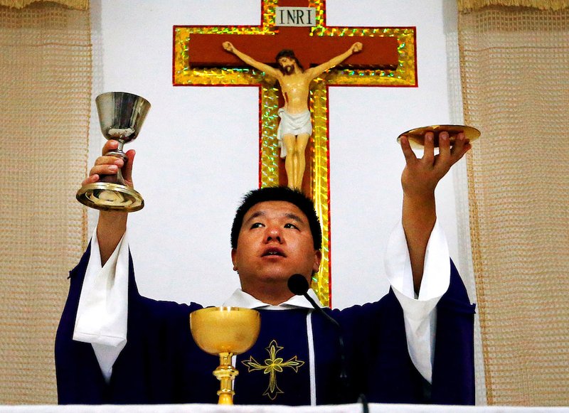 A priest celebrates Mass in a makeshift chapel in a village near Beijing in 2012. The Vatican has told bishops and priests in China that they must follow their own consciences in deciding whether to register with the government