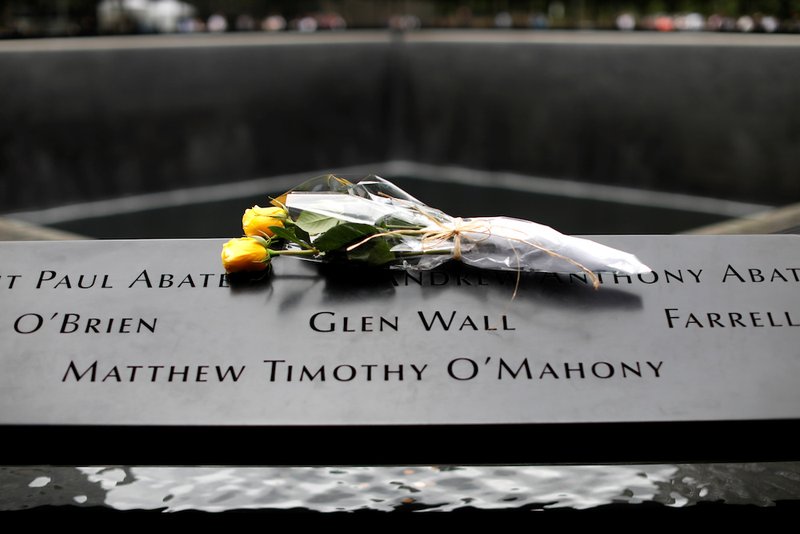 Flowers are seen left at the edge of the north reflecting pool at the 9/11 Memorial and Museum in New York City