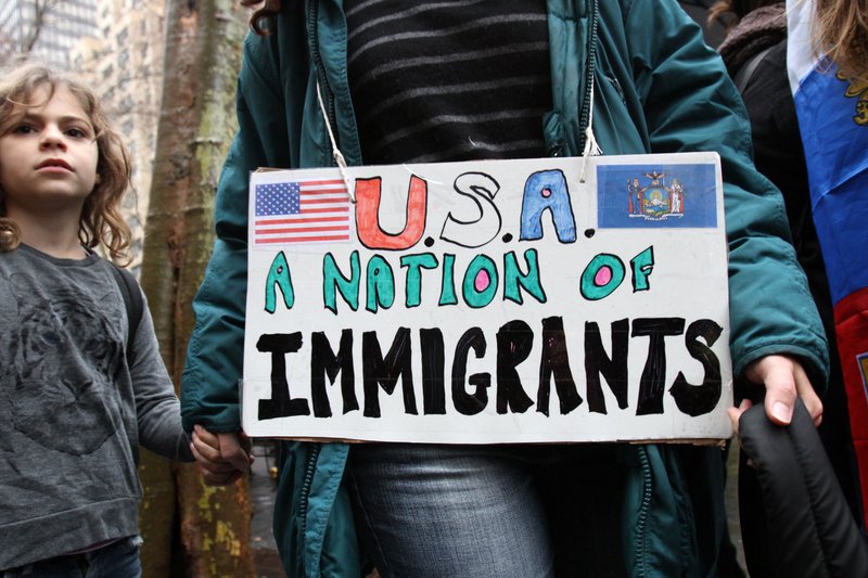 A woman holds a child's hand as they arrive for a rally in support of immigrants' rights in New York City Dec. 18