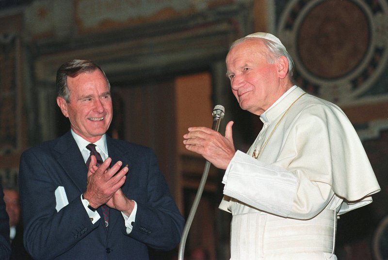 U.S. President George H.W. Bush applauds St. Pope John Paul II after a welcoming ceremony prior to their audience at the Vatican in 1991. Bush