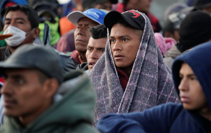 Migrants wait in line to get into buses in Saltillo