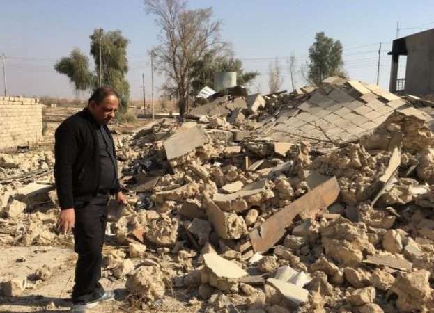 A priest examines a church destroyed by Islamic State militants in Karemlesh. Photo courtesy of the Knights of Columbus.