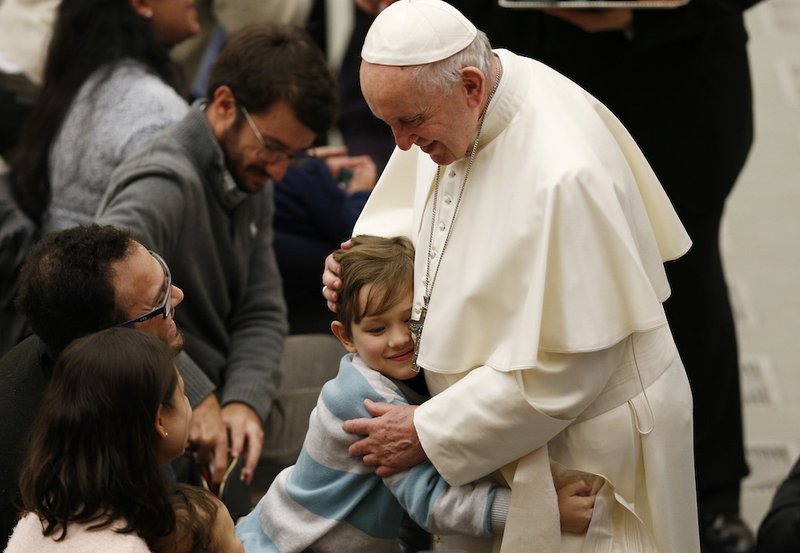 A boy embraces Pope Francis during his general audience in Paul VI hall at the Vatican Jan. 9. (CNS photo/Paul Haring)