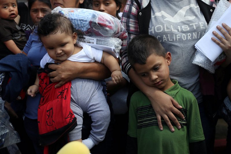 Immigrant children react as they are released from detention at a bus depot June 22 in McAllen