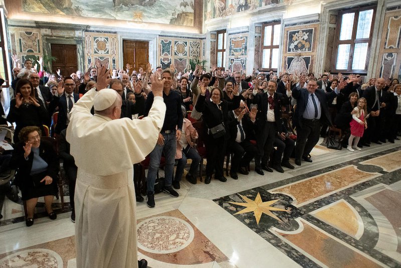Pope Francis waves during a meeting with members of the Italian Federation of Associations for the Deaf at the Vatican April 25