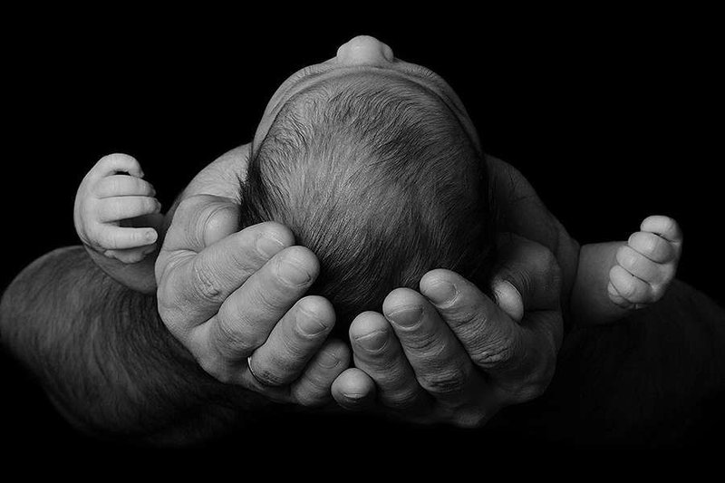 Baby in parent's arms. Credit: geliatida via Shutterstock.