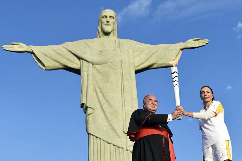 Cardinal Orani Joao Tempesta holds the Olympic torch with former Olympian Isabel Salgado in Rio